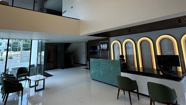 A modern lobby with a reception desk, seating area, and a chandelier. - Hotel Mysore Radiance (Mysore)