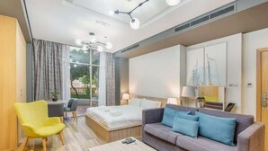 Una habitación de hotel moderna con cama, sofá, mesa de centro y escritorio.