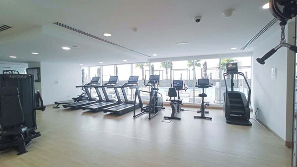 A gym with treadmills, elliptical machines, and a weight machine.