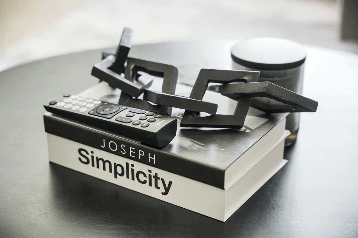 Um livro intitulado 'JOSEPH Simplicity' com um controle remoto em cima.