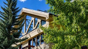 A multi-story building with stone facade, balconies, and a sign for 'Vail Realty.' - Strawberry Park 109 2 Bedroom Condo (Avon)