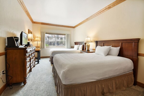 A hotel room with two beds, a wooden dresser, a television, and a window with a view of the outside. - Villa 1082 3 Bed 3 Bath Full Kitchen 3 Bedroom Villa (Midway)