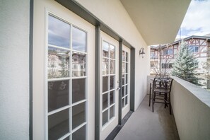 Enjoy the view from this spacious balcony with large windows and a comfortable chair.