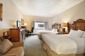 Two single beds with matching headboards and footboards, a dresser, flat-screen TV, and desk with chair.