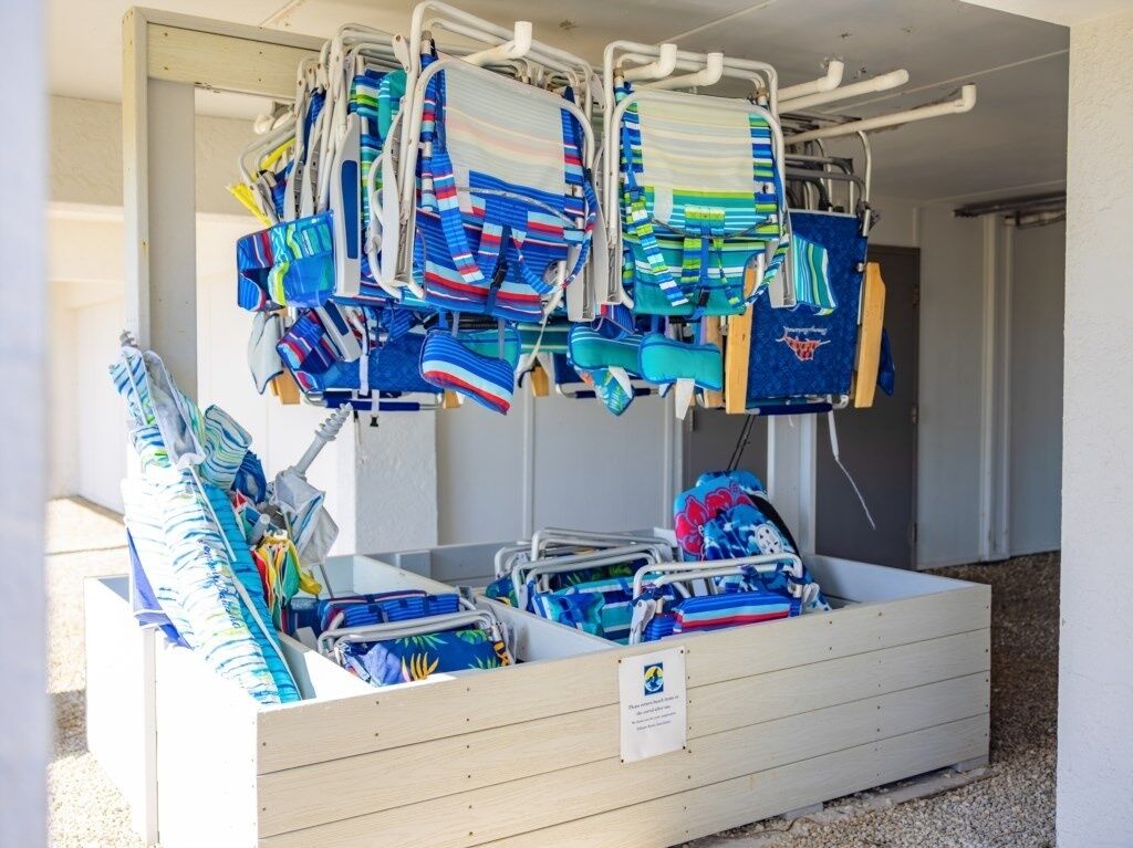 A storage area with multiple shelves holding various items, including folded towels and bags.