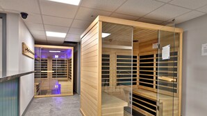 Un pasillo con un mueble de madera y una puerta de cristal que da a una habitación con estanterías.