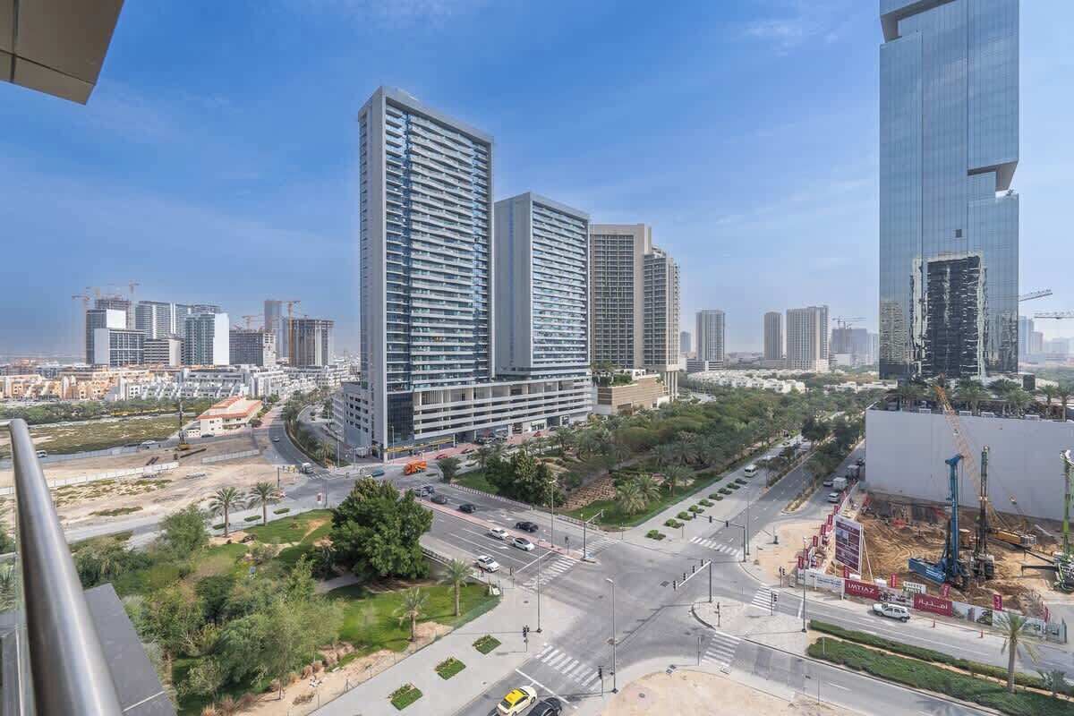 A modern urban landscape with high-rise buildings, a busy intersection, and construction sites.