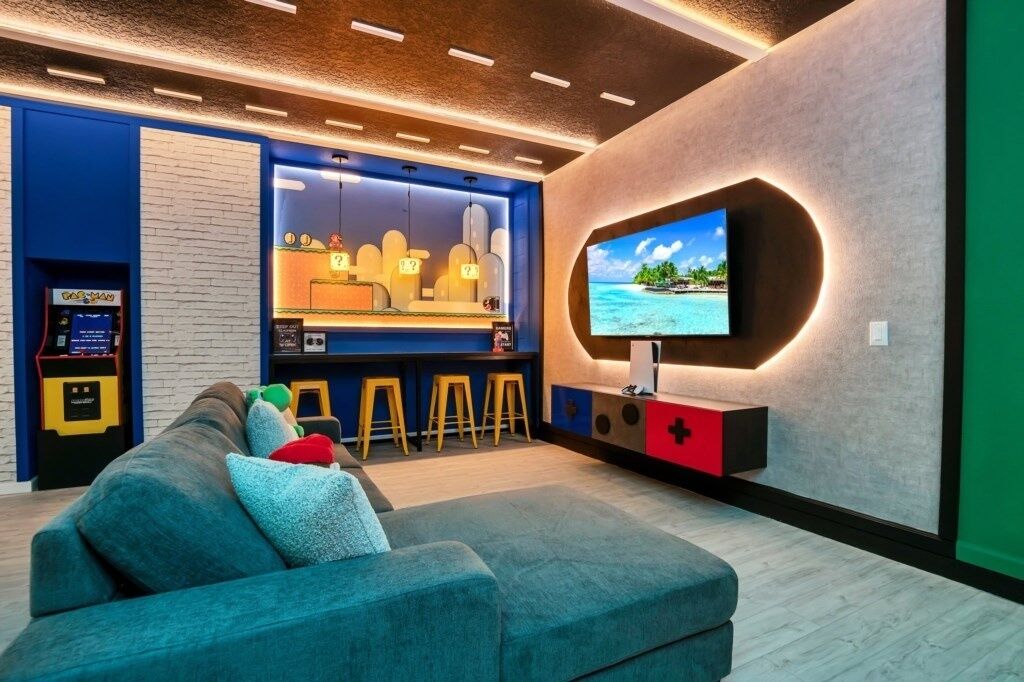 Un salon moderne avec un grand téléviseur, un coin bar et un canapé.