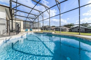 A swimming pool with a glass enclosure, surrounded by a metal frame and a clear sky. - Mickey & Mario's Fun House 12 Min From Disney! 4 Bedroom Home (Davenport)