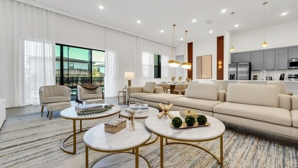 Un salon moderne comprenant un canapé, deux tables basses et un coin repas avec une table et des chaises.