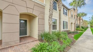 A row of townhouses with a brick pathway and palm trees. - Themed Bedrooms & Private Pool Gated in Fun Resort 4 Townhouse (Kissimmee)