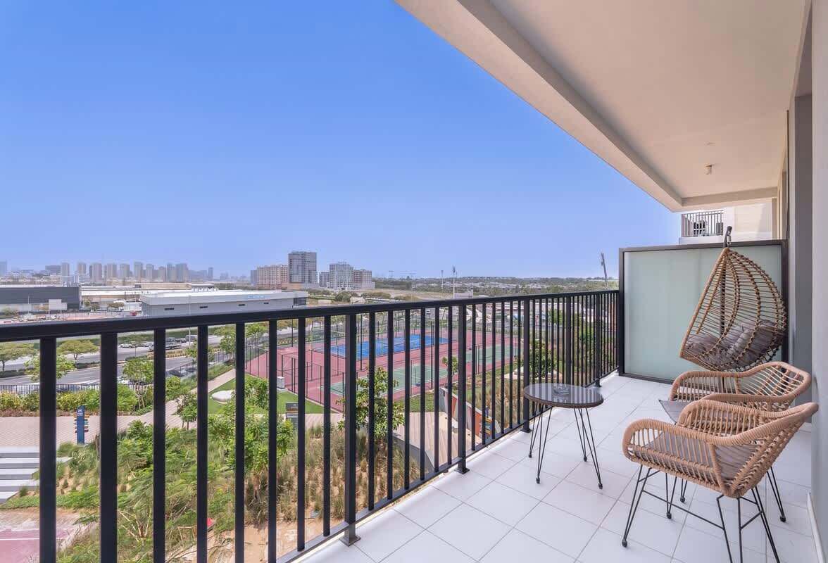 Un balcone con vista su un campo sportivo e sulla città.