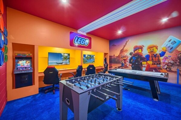 Une pièce lumineuse, équipée d’un baby-foot, de consoles de jeux et d’une grande fresque murale sur le thème de LEGO.
