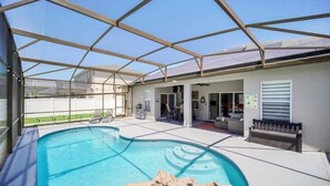 Piscina coberta ao ar livre com área de terraço, assentos e vista para a paisagem circundante.