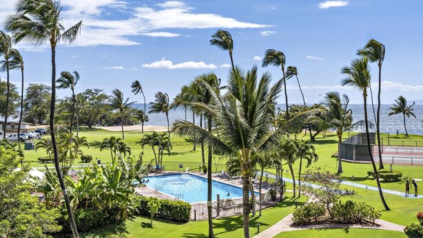 A pool surrounded by palm trees and a golf course. - Maui Sunset A412 1 Bedroom Condo (Kihei)