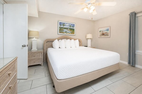 A bedroom with a large bed, two bedside tables, a ceiling fan, and two wall-mounted lamps. - Phoenix V 411 1 Bedroom Condo (Orange Beach)