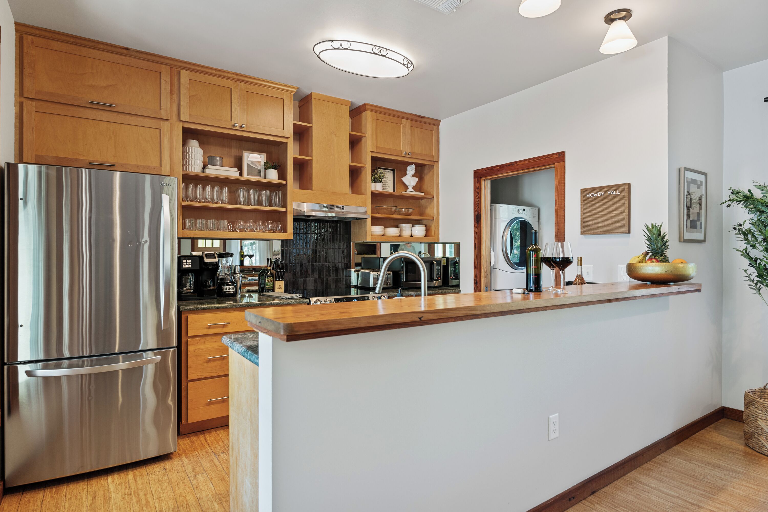 A modern kitchen with wooden cabinets, stainless steel appliances, and a central island with a sink.