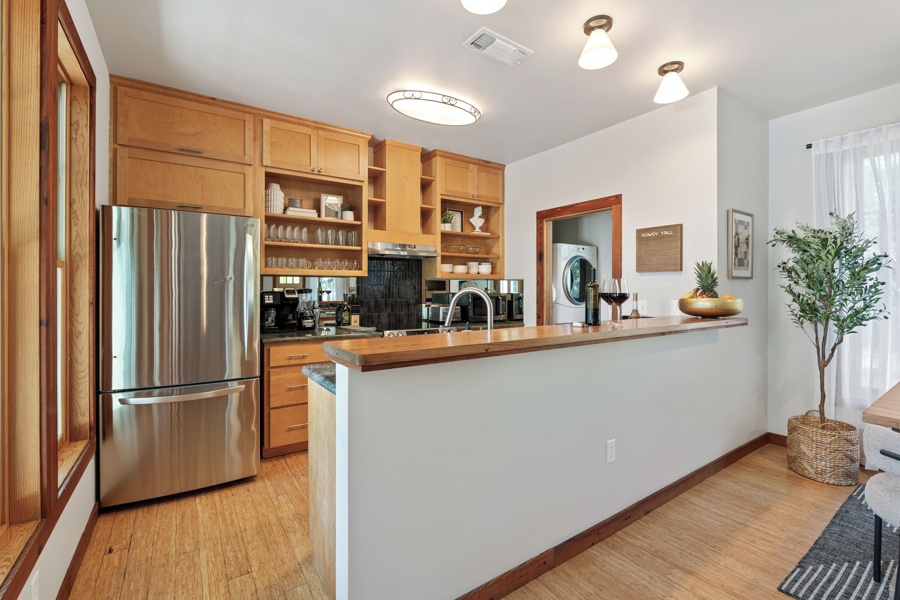 A modern kitchen with wooden cabinets, stainless steel appliances, and a central island.