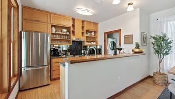 A modern kitchen with wooden cabinets, stainless steel appliances, and a central island.