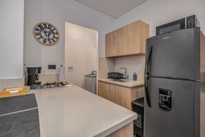 Fridge, microwave, coffee/tea maker, cookware/dishes/utensils