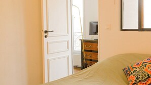 A bedroom with a bed, a dresser, and a television.