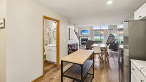 A modern kitchen with a dining area, wooden flooring, and a view of the outdoors. - Waterfront Boho Retreat (Wisconsin Dells)