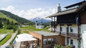 Ein Hotel mit Balkon, Essbereich und Bergblick.
