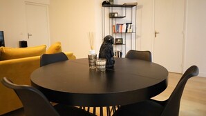 A round dining table with black chairs, a black decorative item, and two glasses on the table. - Prestigious Apartment - Faubourg Saint-Honoré (Paris)
