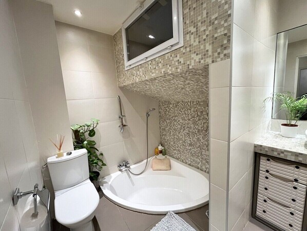 A modern bathroom with a toilet, sink, and bathtub.