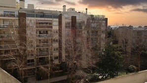 A multi-story residential building with balconies, a courtyard, and a sunset sky. - Garden View Apartment near Canal Saint-Martin (Paris)