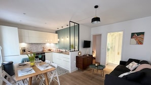 Een modern appartement met keuken, eethoek en zithoek.