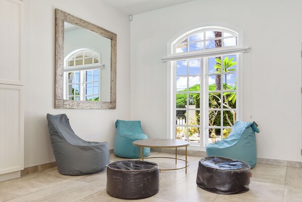 A room with a large arched window, a round table, and two bean bag chairs. - Westpunt 12-c (Noord)