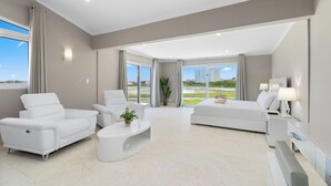 A modern living room with a sofa, armchairs, a coffee table, and a TV. - Salinja Cerca 23-b (Noord)