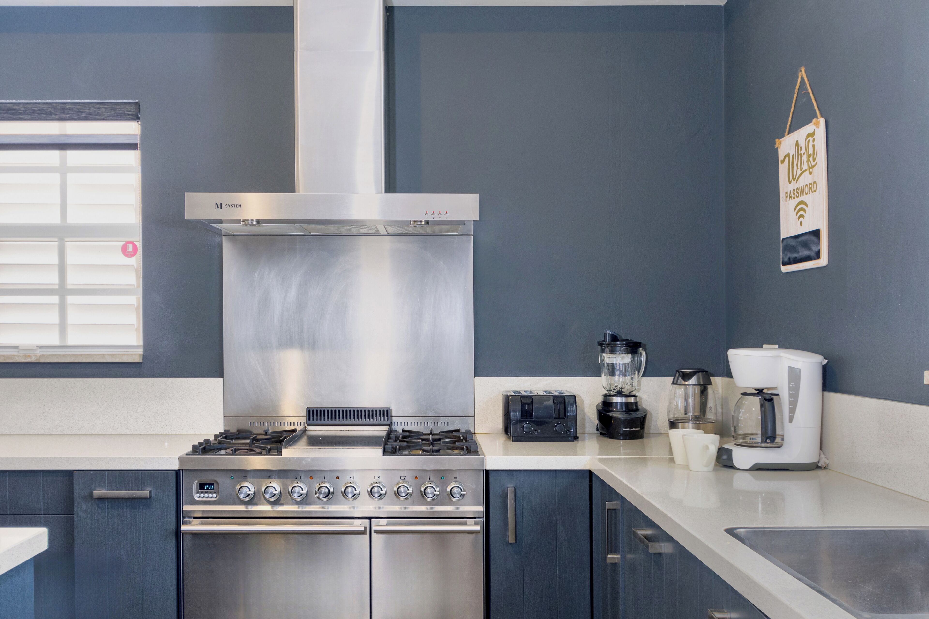 A modern kitchen with stainless steel appliances, a built-in oven, and a coffee maker.