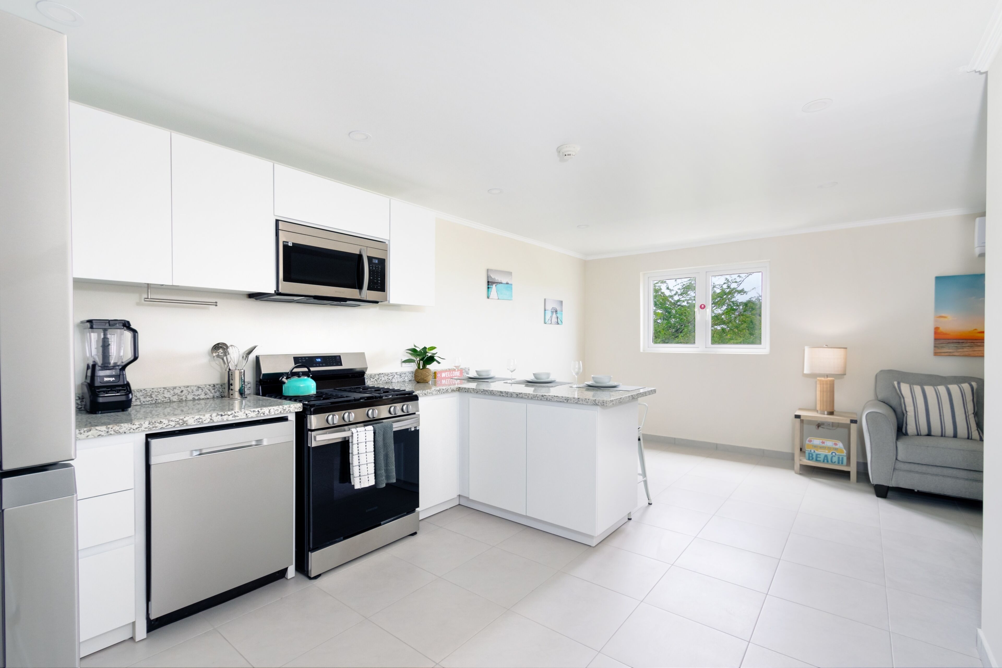 A modern kitchen with white cabinets, a built-in microwave, a stove, and a dishwasher.