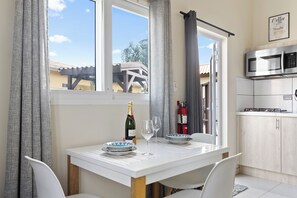 Enjoy meals in the kitchen, adjacent to a dining area with a table for two.