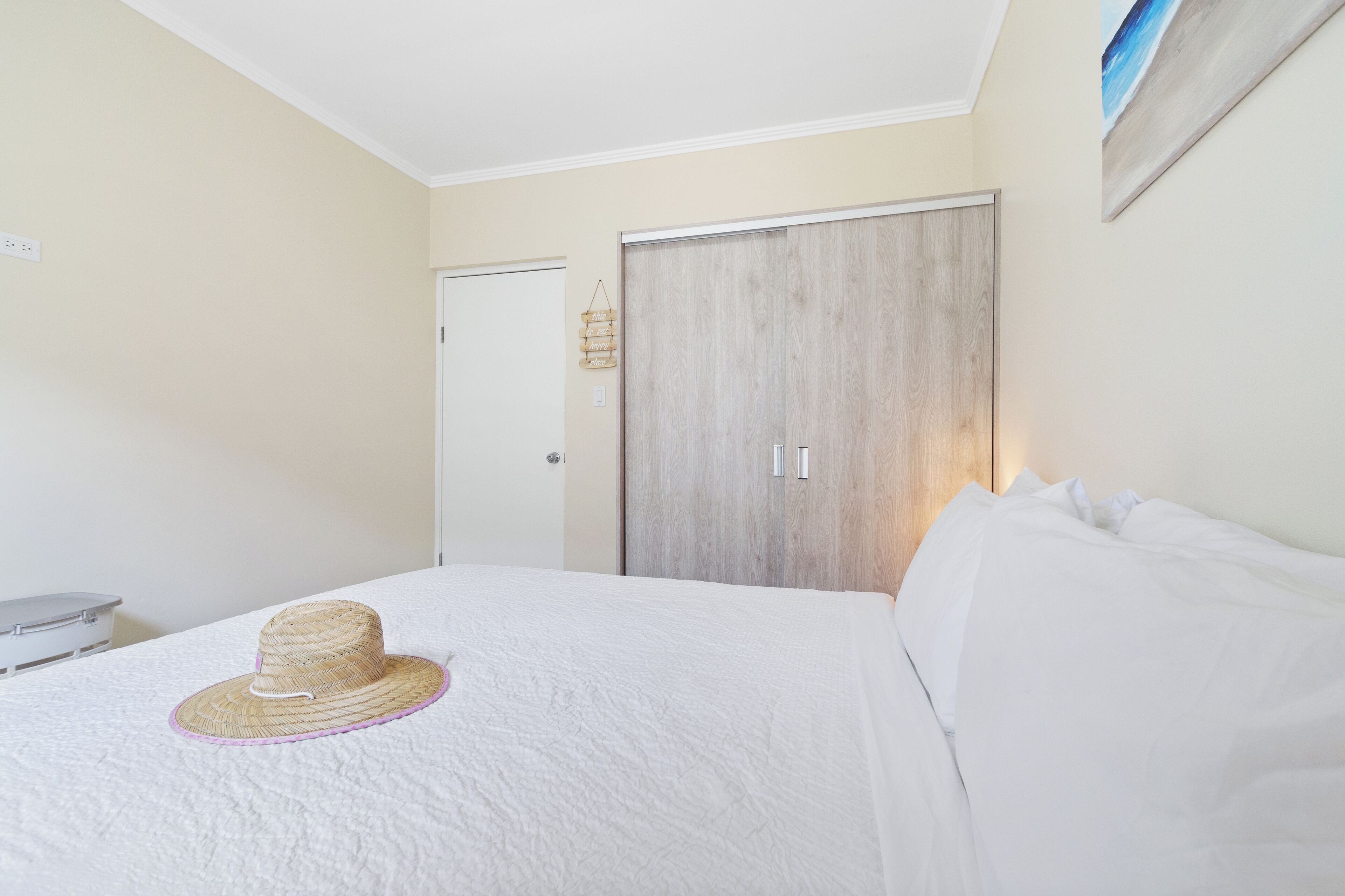 A bedroom with a bed, a wardrobe, and a door.