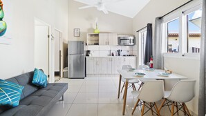 Uma cozinha moderna com área de jantar, sofá e ventilador de teto.