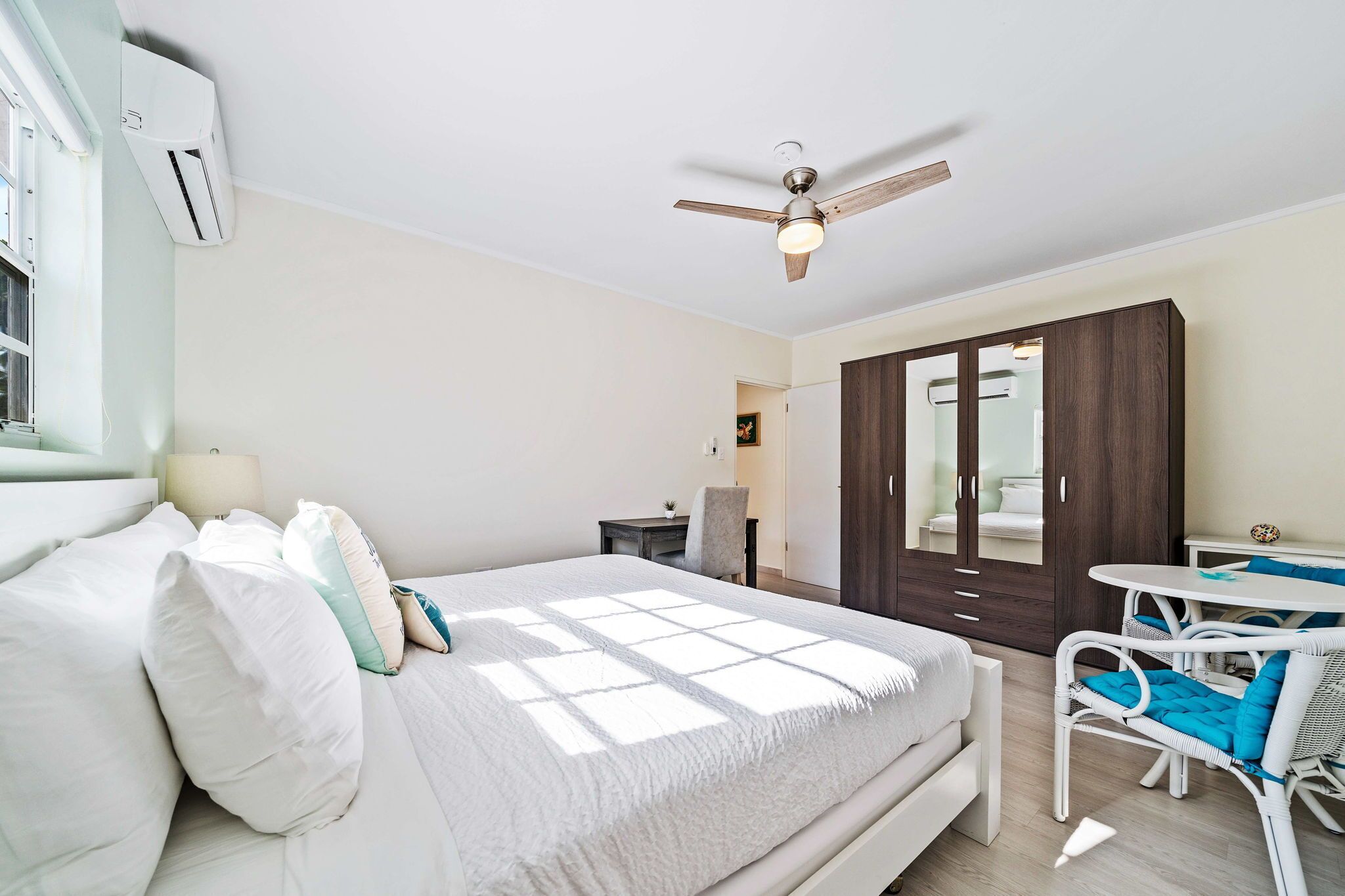 A bedroom with a bed, a desk, a chair, and a wardrobe.