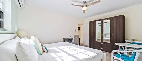 A bedroom with a bed, a desk, a chair, and a wardrobe.