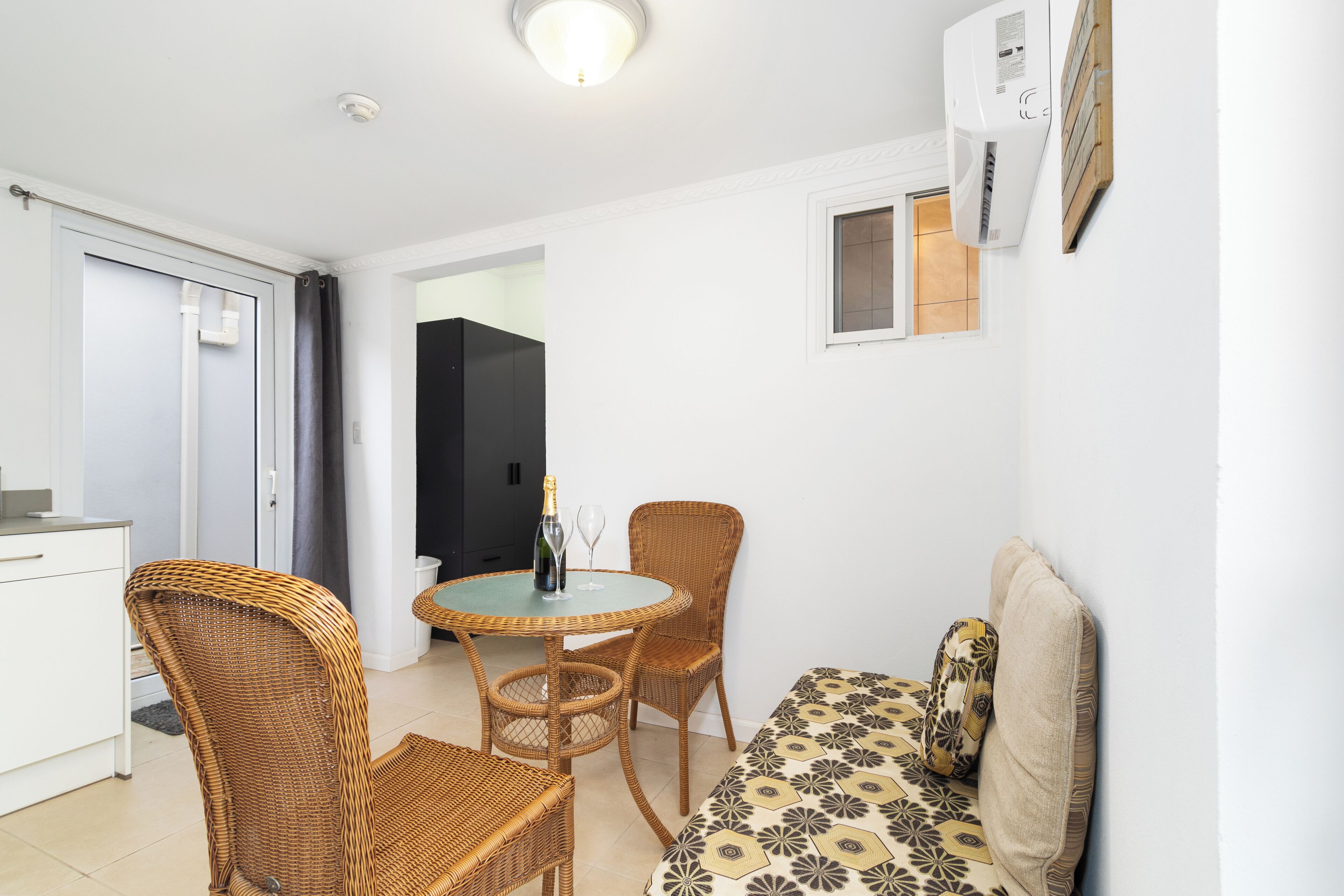 Un espai habitable compacte amb zona de menjador, sofà i petita cuina.