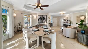 A spacious living room with a dining area, a ceiling fan, and a view of the outdoors. - Safir 8 (Noord)