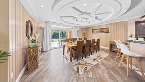 A dining area with a wooden table, wicker chairs, and a glass-top coffee table. - Divi Village Condo 33 J.e. Irausquin Blvd 93 (Oranjestad)