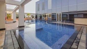 An indoor swimming pool with clear water, surrounded by a modern building with large windows and a tiled floor. - StayShort - Sky Gardens Studio with Skyscraper Views in DIFC! (DIFC)