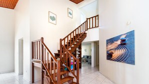 A wooden staircase in a well-lit room with white walls and a tiled floor. - Koyari 36-f (Noord)