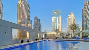 Piscina no terraço com vista para edifícios altos.