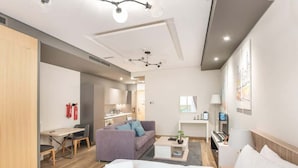 Une chambre d’hôtel moderne équipée d’un lit, d’un canapé, d’un bureau et d’une kitchenette.