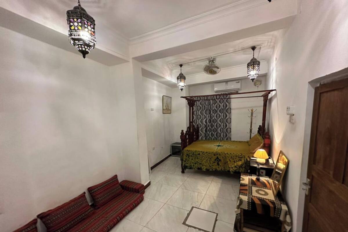 Une chambre à coucher comprenant un lit, un canapé, une table de chevet et une armoire.