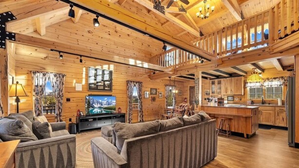 A wooden cabin interior with a living room, kitchen, and a balcony. - Remmert`s Log Haven - Tranquil Mountain Getaway (Estes Park)