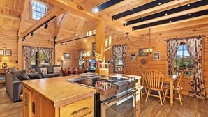 A wooden cabin interior with a kitchen, dining area, and living room. - Remmert`s Log Haven - Tranquil Mountain Getaway (Estes Park)